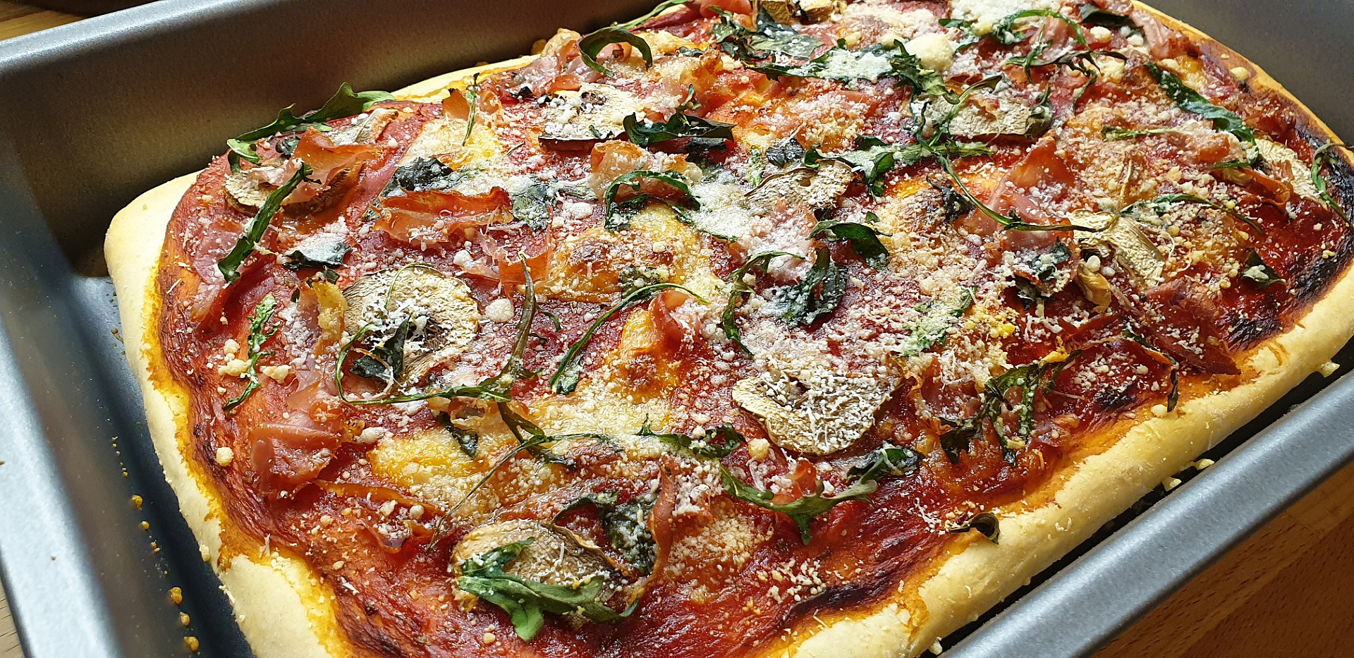 Domácí pizza s prosciuttem a rukolou