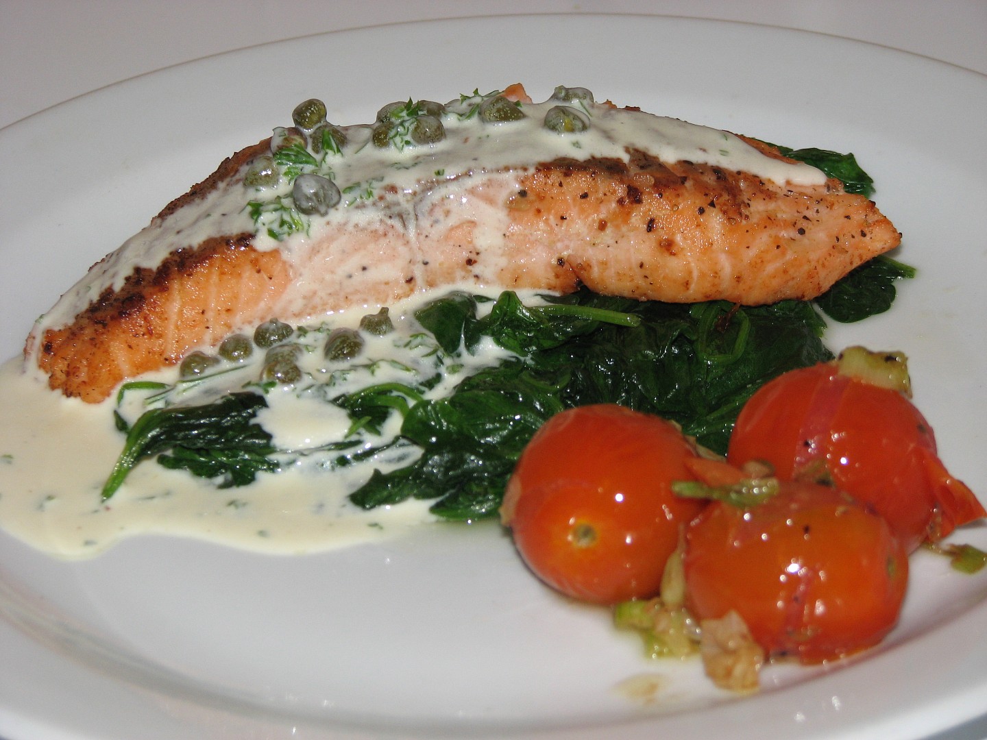 Losos na špenátu s kaparovým přelivem a rajčátky na másle