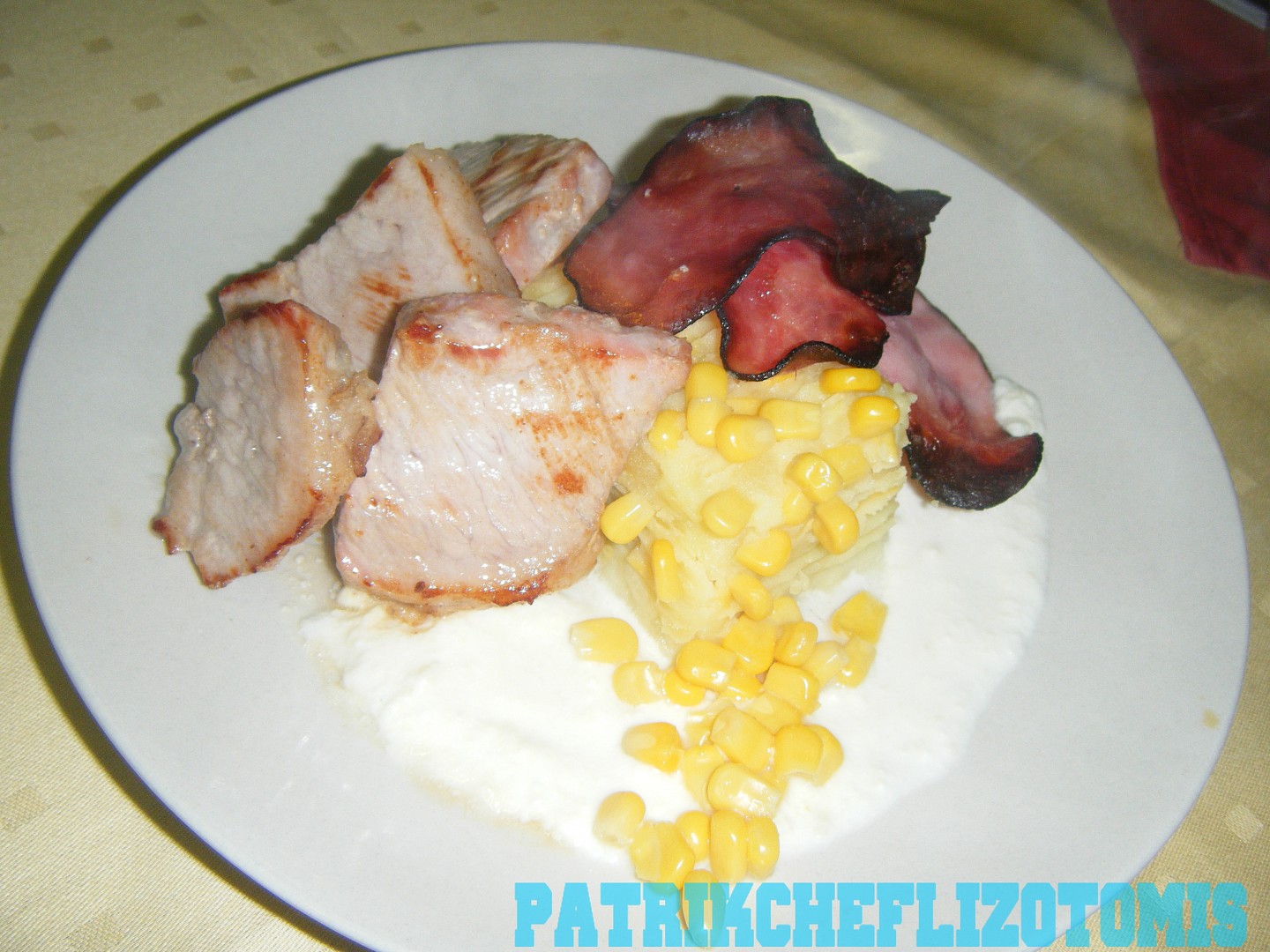 Vepřová panenka s bramborovo-kukuřičným dortíkem a sýrovou omáčkou, ozdobené slaninou